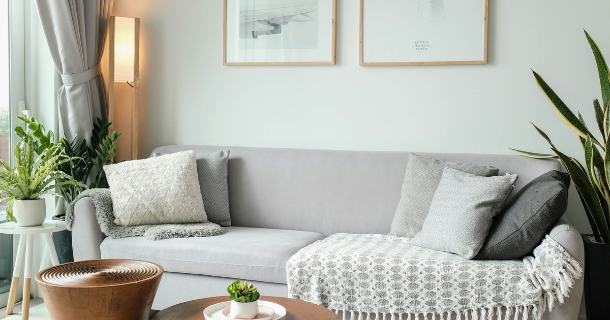 Bright, neatly staged living room with a gray sofa and plants, showing how to prepare your home for sale in Red Bank, NJ